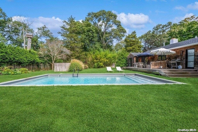 view of swimming pool with a deck and a yard