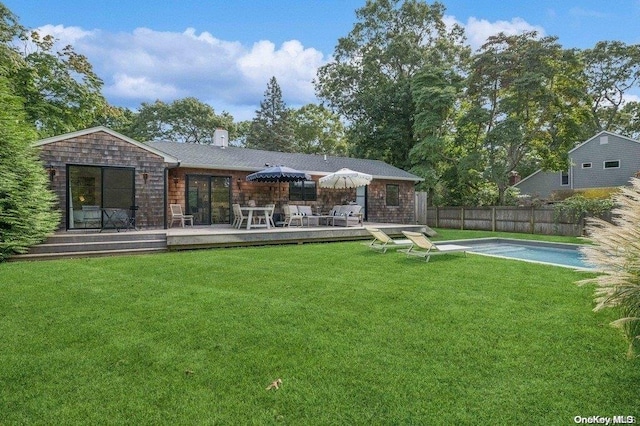 rear view of property featuring a lawn and a deck