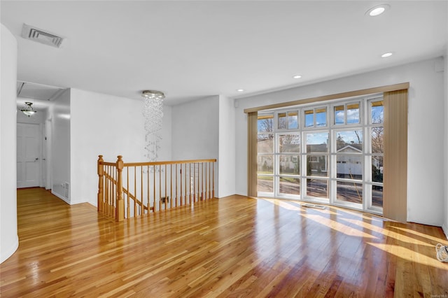 spare room with recessed lighting, visible vents, wood-type flooring, and attic access