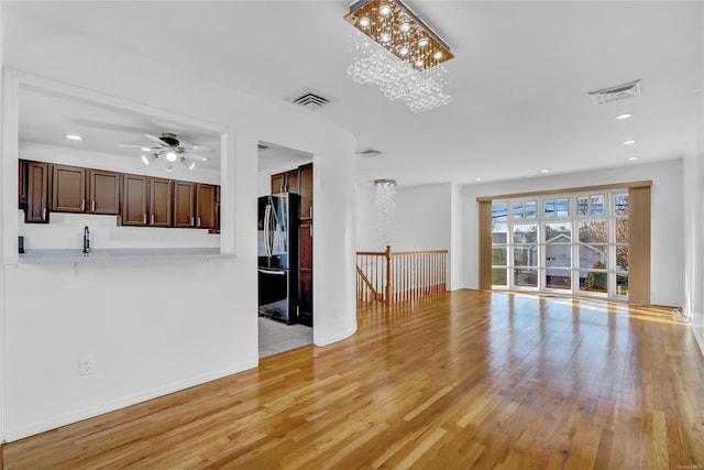 unfurnished living room featuring visible vents, recessed lighting, and light wood-type flooring