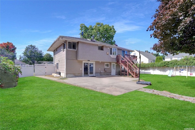 rear view of property featuring a patio, a gate, a fenced backyard, stairs, and a lawn