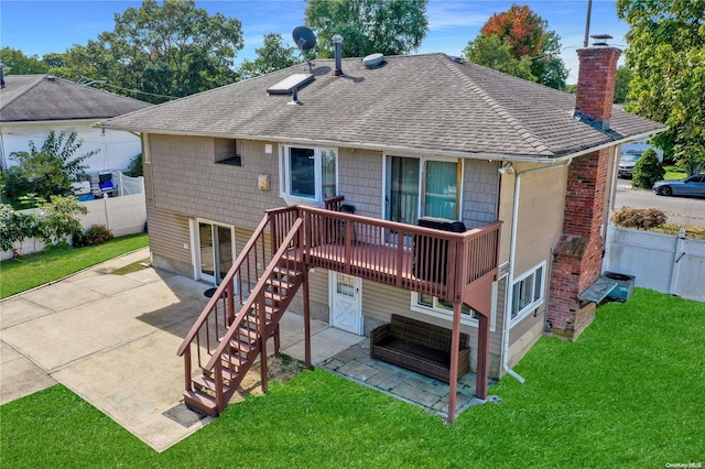 rear view of house with concrete driveway, a yard, a patio area, and fence