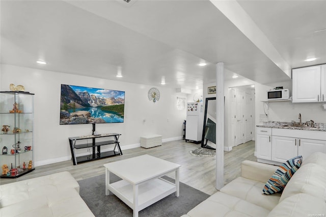 living area with recessed lighting, baseboards, and light wood-style floors