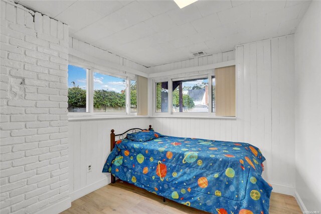 bedroom featuring visible vents, baseboards, and wood finished floors