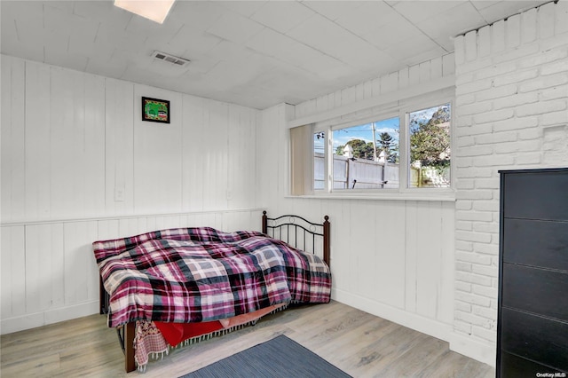 bedroom with visible vents, baseboards, and wood finished floors