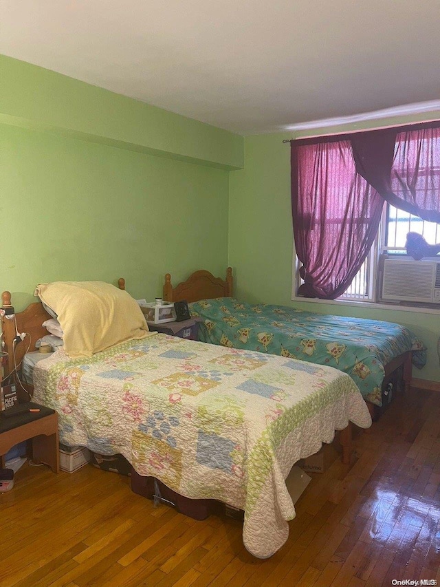 bedroom featuring hardwood / wood-style floors and cooling unit