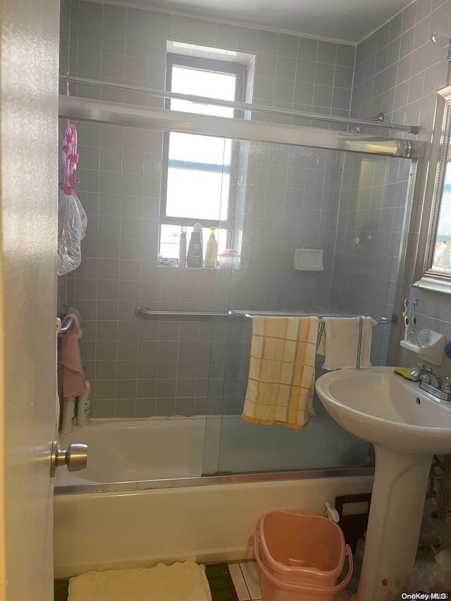 bathroom with bath / shower combo with glass door