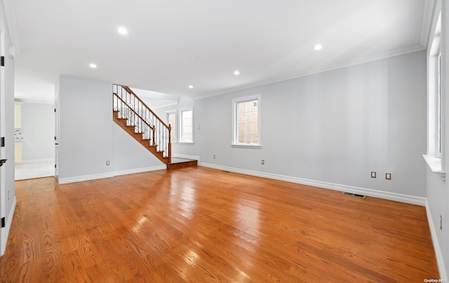 spare room featuring light hardwood / wood-style flooring and crown molding