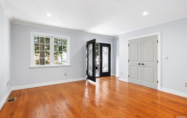 foyer with french doors, light hardwood / wood-style floors, and ornamental molding