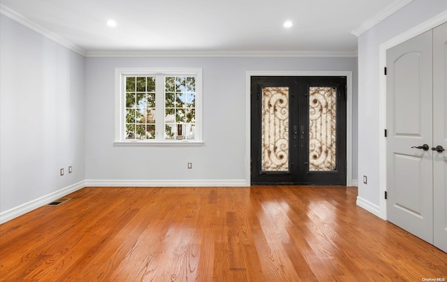 foyer entrance featuring french doors, ornamental molding, and light hardwood / wood-style flooring