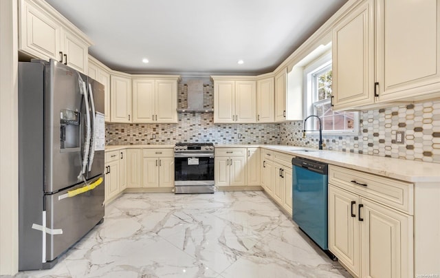 kitchen with sink, wall chimney range hood, backsplash, cream cabinetry, and appliances with stainless steel finishes