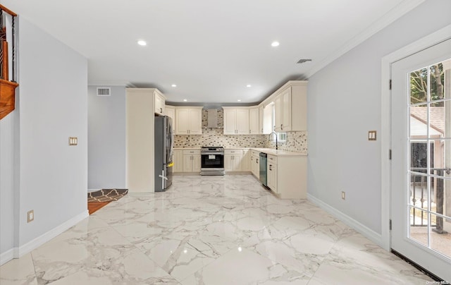 kitchen featuring cream cabinets, ornamental molding, a healthy amount of sunlight, and appliances with stainless steel finishes