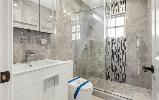 bathroom with vanity, toilet, an enclosed shower, and tile walls