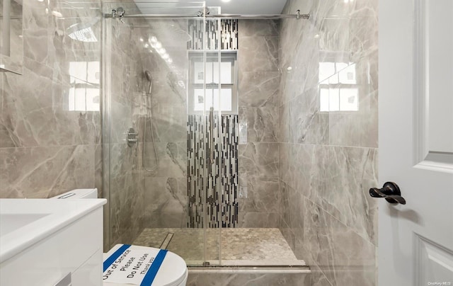 bathroom with vanity, a shower with door, toilet, and plenty of natural light