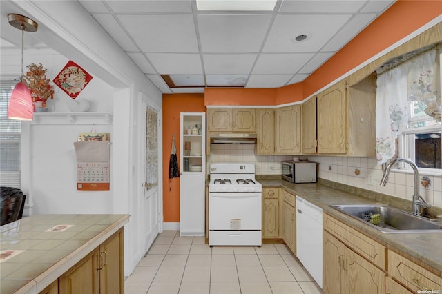 kitchen with sink, pendant lighting, white appliances, a paneled ceiling, and light tile patterned flooring