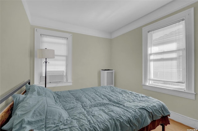 bedroom with wood-type flooring, cooling unit, and crown molding