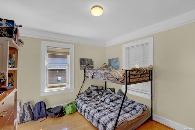 bedroom featuring hardwood / wood-style flooring and crown molding