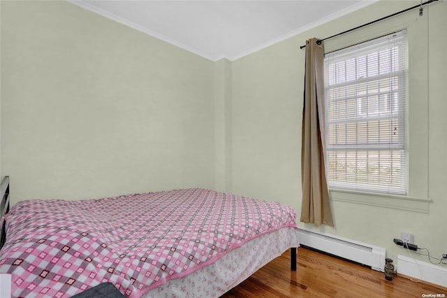 bedroom with hardwood / wood-style floors, ornamental molding, and a baseboard radiator