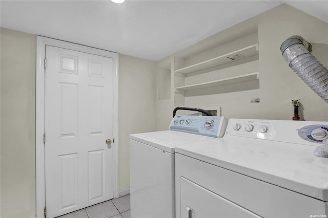 laundry area with independent washer and dryer and light tile patterned floors