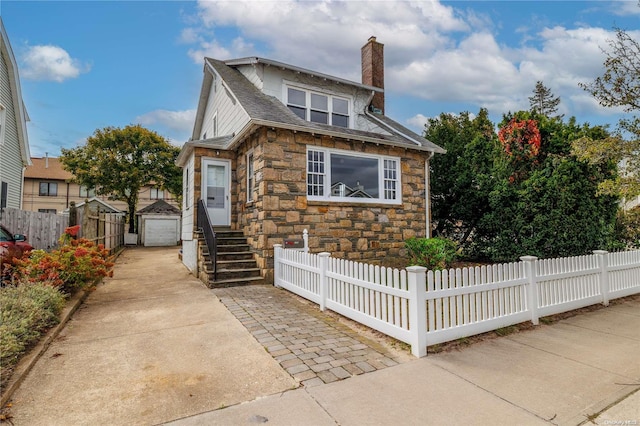 view of front of property with a garage and an outbuilding