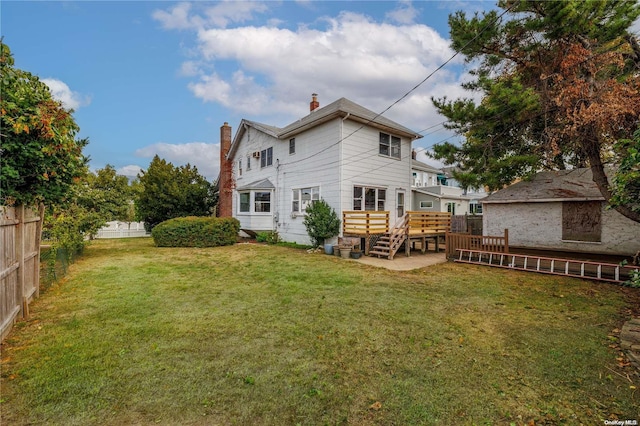 back of property with a wooden deck and a yard