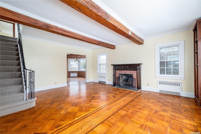 unfurnished living room with radiator, crown molding, a fireplace, and parquet floors