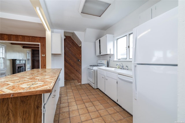 kitchen with white cabinetry, white appliances, sink, and light tile patterned floors