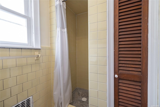 bathroom featuring tile walls and walk in shower