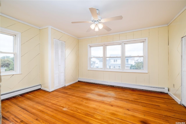 unfurnished room with light hardwood / wood-style floors, a healthy amount of sunlight, and a baseboard heating unit