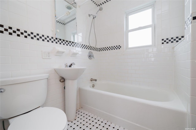 bathroom featuring tile patterned floors, tiled shower / bath combo, tile walls, and toilet