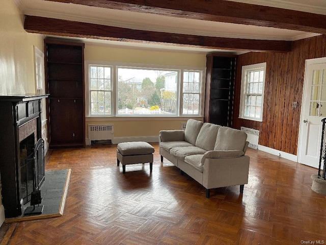 living room with wooden walls, beam ceiling, and radiator