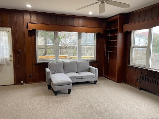 sitting room with radiator, wooden walls, and plenty of natural light