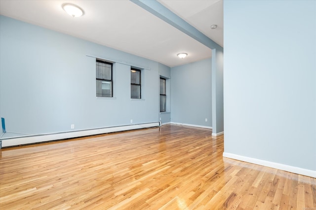 unfurnished room featuring light wood-type flooring and a baseboard radiator