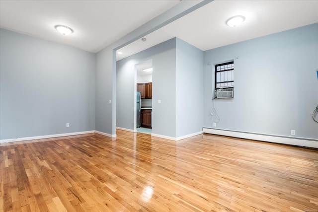 unfurnished room featuring light wood-type flooring, a baseboard radiator, and cooling unit