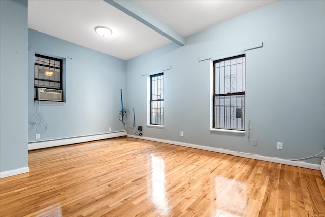 unfurnished room with cooling unit, beam ceiling, light hardwood / wood-style flooring, and a baseboard heating unit