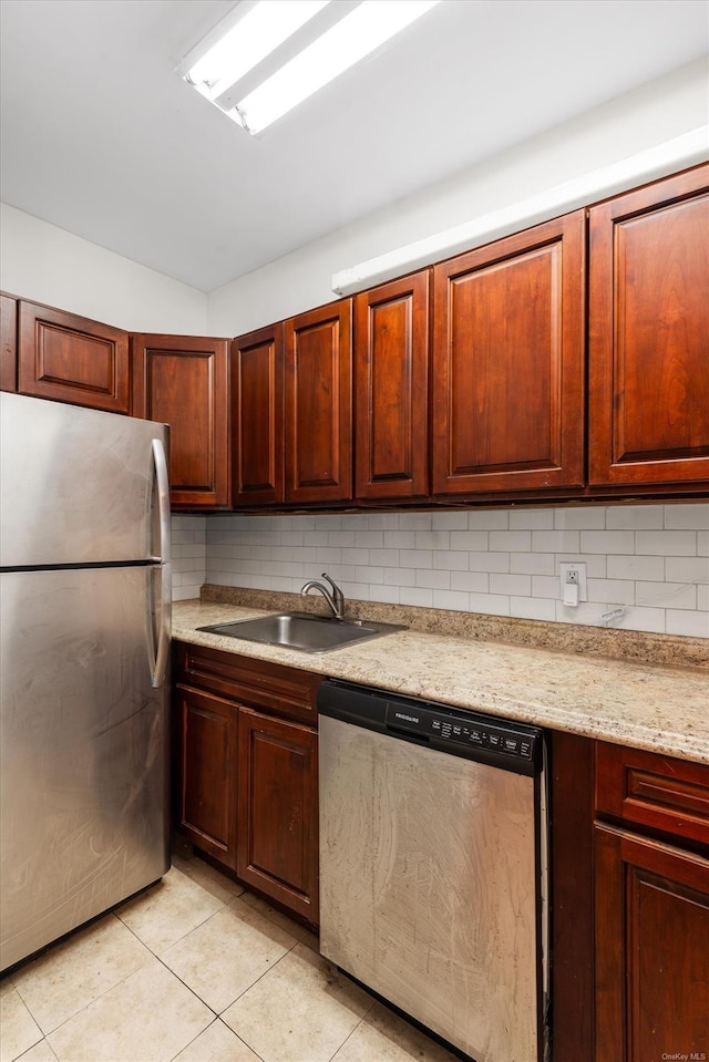 kitchen with decorative backsplash, sink, light tile patterned floors, and stainless steel appliances