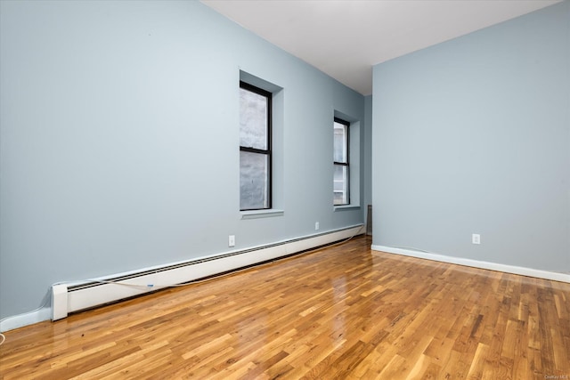 unfurnished room with light wood-type flooring and baseboard heating