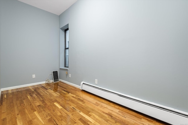 empty room with light wood-type flooring and baseboard heating