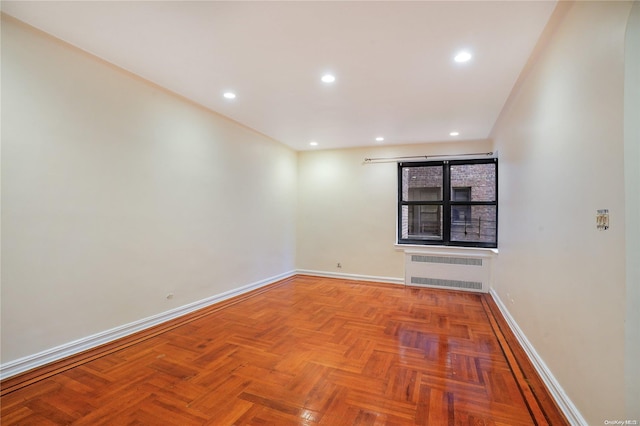 unfurnished room featuring radiator heating unit and parquet flooring