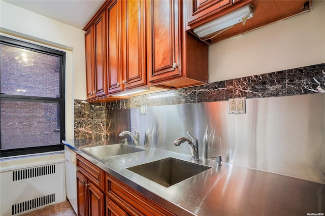 kitchen featuring decorative backsplash, white dishwasher, radiator, and sink