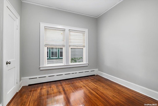 empty room with wood-type flooring, baseboard heating, and crown molding