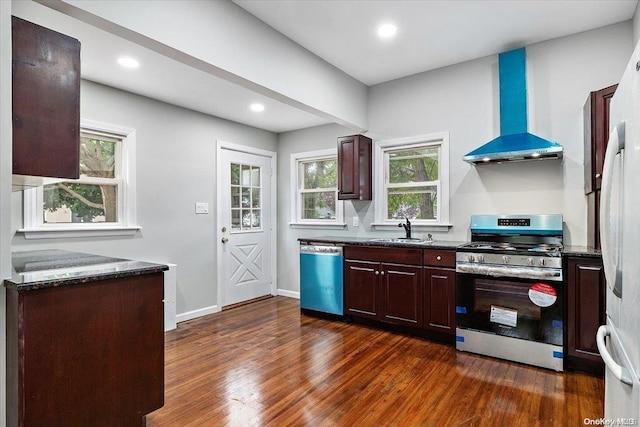 kitchen with a healthy amount of sunlight, stainless steel appliances, dark hardwood / wood-style floors, and wall chimney exhaust hood