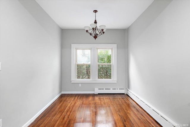 unfurnished room featuring a notable chandelier, wood-type flooring, and a baseboard radiator