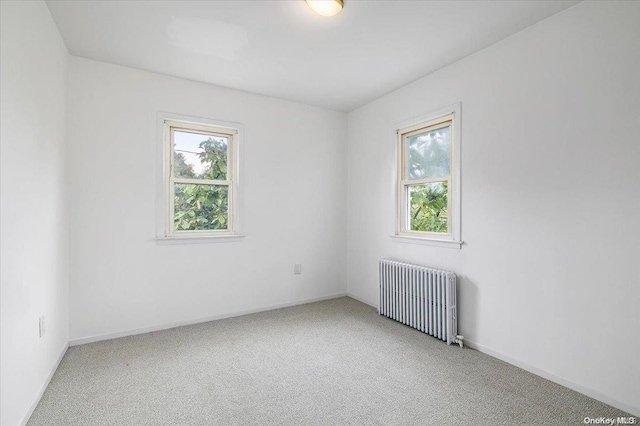 empty room with carpet and radiator heating unit