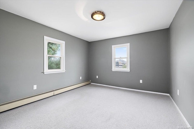 carpeted empty room featuring plenty of natural light and a baseboard radiator