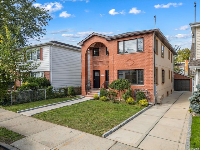 view of front of house with brick siding, a front yard, fence, and an outdoor structure