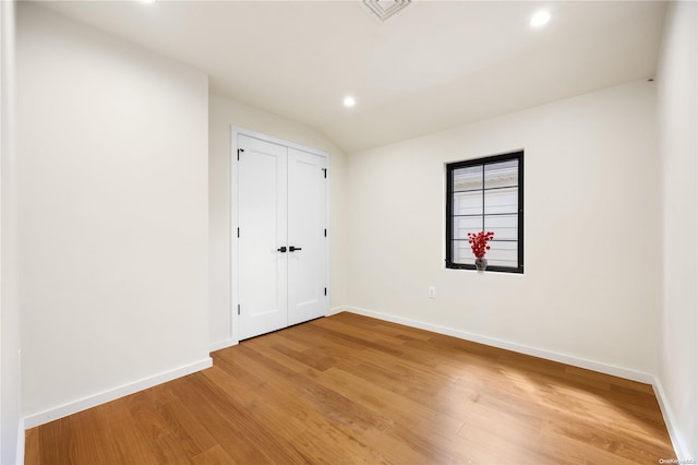 empty room featuring hardwood / wood-style floors and lofted ceiling