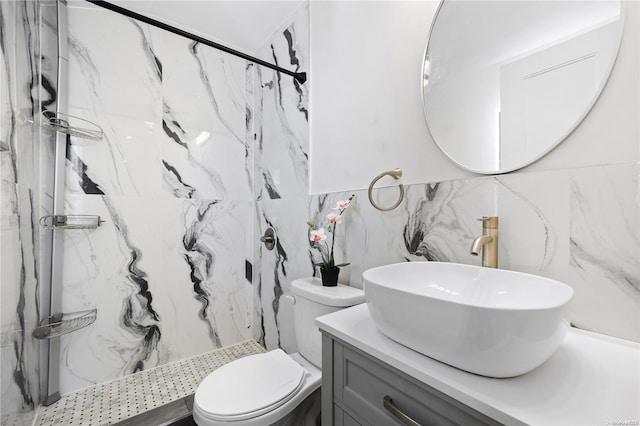 bathroom with vanity, decorative backsplash, toilet, tile walls, and a tile shower