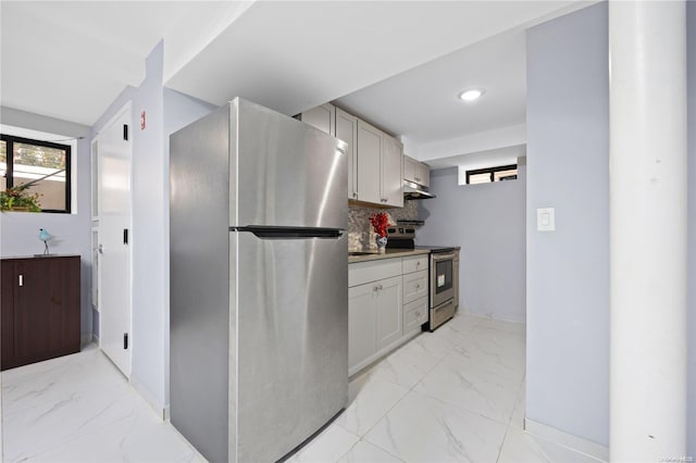 kitchen with tasteful backsplash, marble finish floor, stainless steel appliances, under cabinet range hood, and white cabinetry