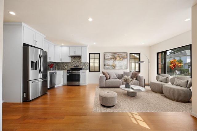 living area with recessed lighting and light wood finished floors